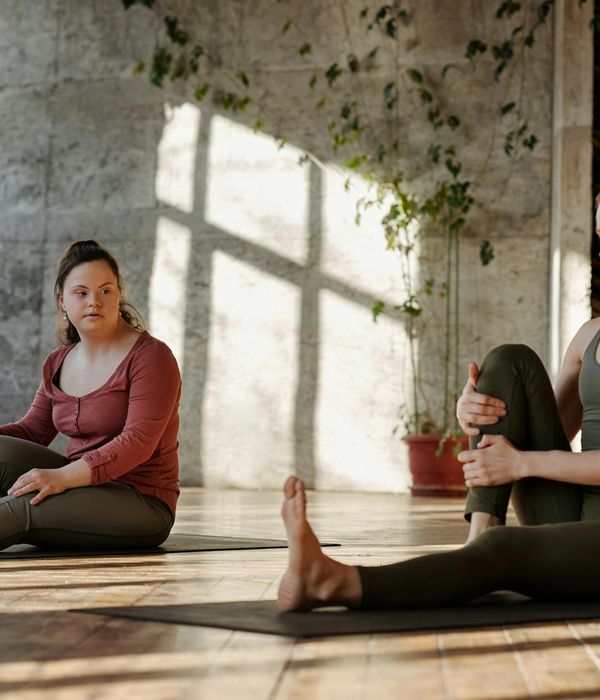 Person stretching peacefully in a bright, sunlit room.